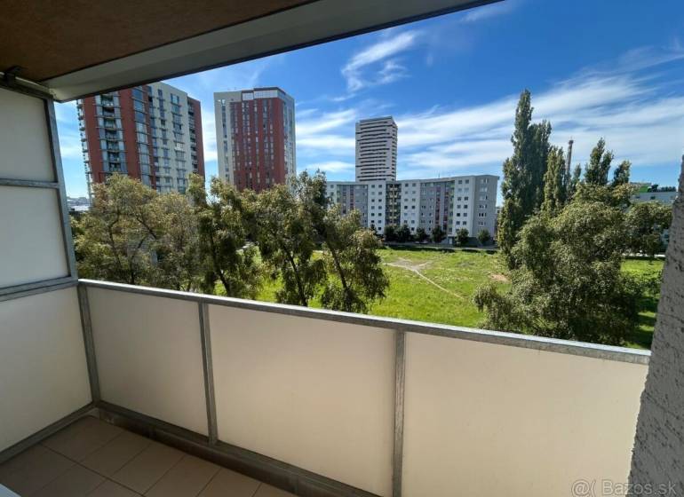 Veľký 2-izb. byt na ul. Vranovská, Petržalka, lodžia, 4.p./7 - Balkón garsónky na Vranovskej ulici v Bratislave - Petržalke s výhľadom na zeleň a paneláky.
