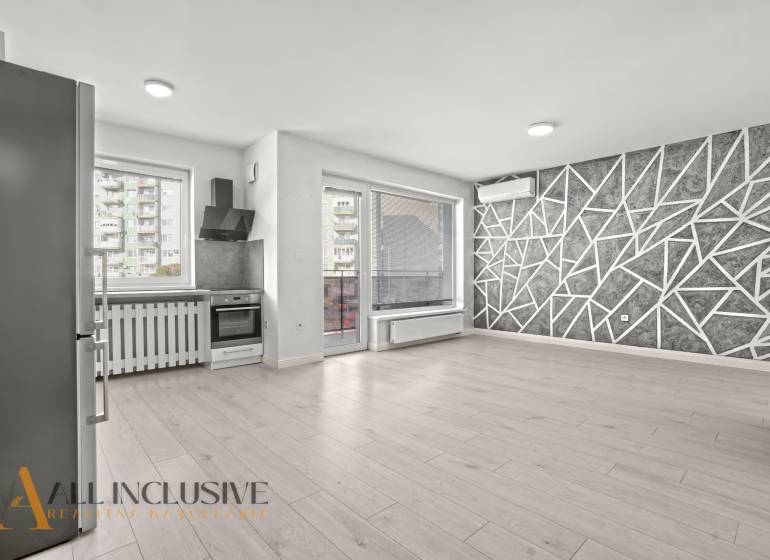 PRENAJATÉ | NA PRENÁJOM 2x 2-IZBOVÉ BYTY S TERASOU,DUNAJSKÁ STREDA - Kuchyňa a obývačka v 2-izbovom byte s podlahou s dreveným dekorom a geometrickou stenou.