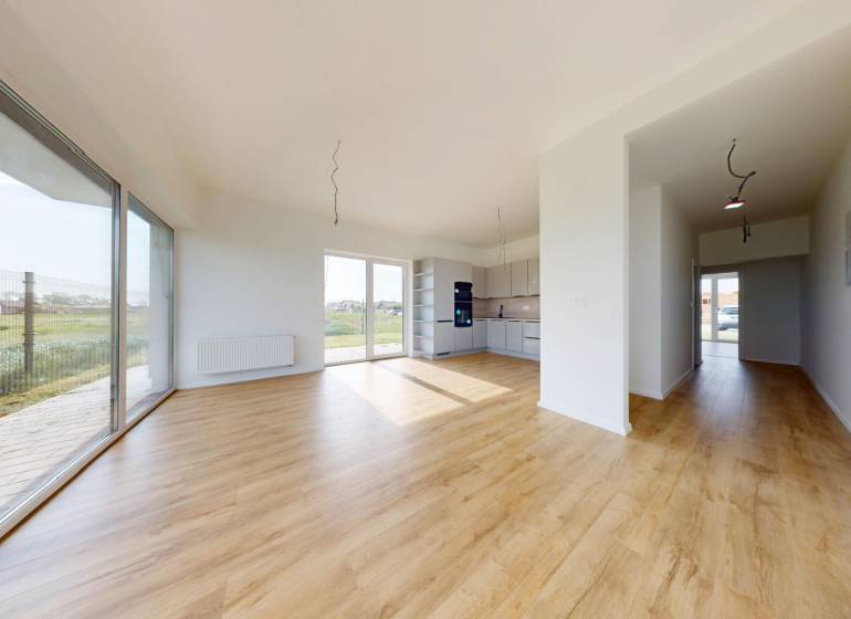 3i. BYT SO ZÁHRADOU +TEP. ČERPADLO, KLIMATIZÁCIA A ŽALÚZIE V CENE - Priestranný obývací priestor v 3-izbovom byte s drevenou podlahou a veľkými oknami.