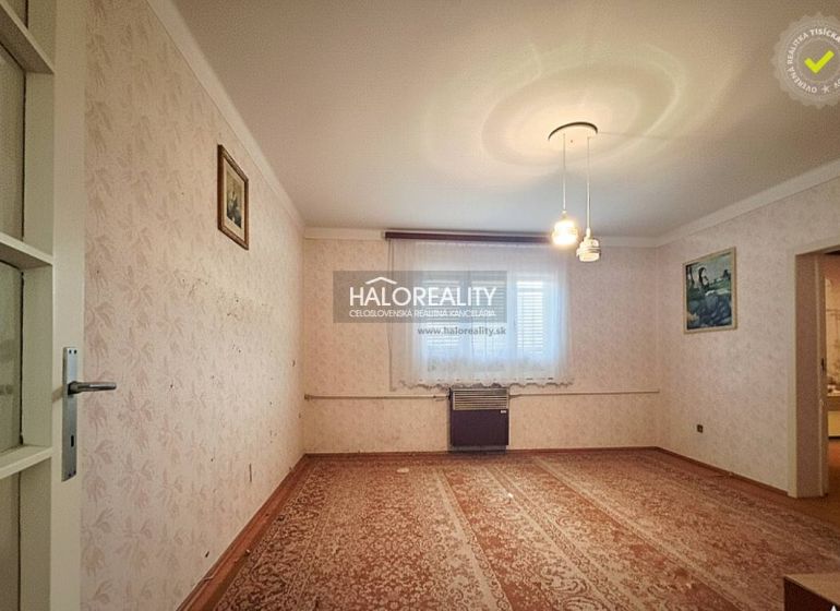 Predaj, rodinný dom Dvory nad Žitavou, dvojizbový, p... - Obývacia izba v rodinnom dome s kobercom, tapetami a nástennými obrazmi.