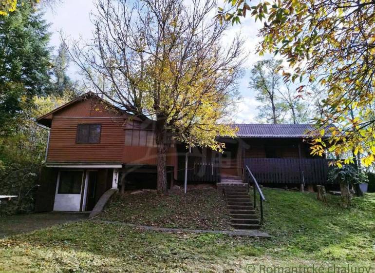 Chata nad kúpeľmi Dudince s vlastným pozemkom - Chata v Dudincoch obklopená stromami a sviežou zeleňou, ideálna na oddych.