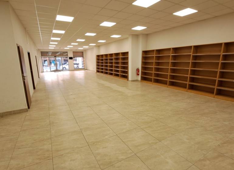 PRENÁJOM: Obchodný priestor 158m2 - Mostová ulica, Ružomberok - Obchodné priestory na prenájom na Mostovej ulici v Ružomberku, s regálmi a podlahou s dreveným dekorom.