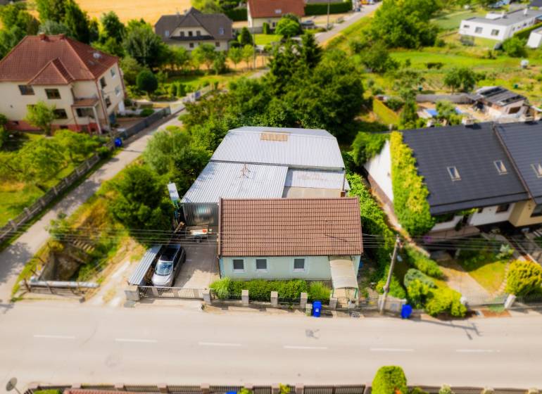 Na predaj rodinný dom s podnikateľským potenciálom, TN-Záblatie - Rodinný dom na Záblatskej ulici v Trenčíne, obklopený zeleňou a ďalšími domami.