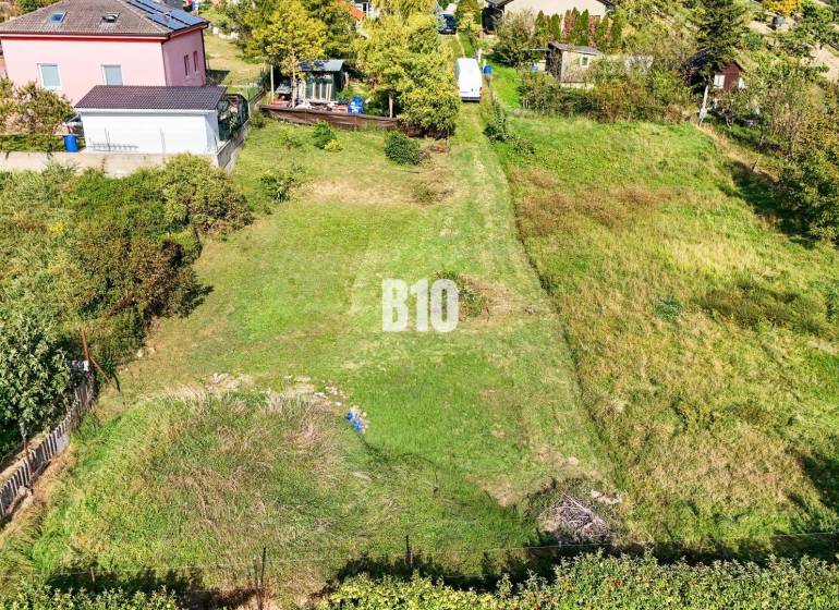 Stavebný pozemok so stavebným povolením - Janíkovce - 729 m2 - Pozemky - bývanie v Nitre s upravenou záhradou a okolitými domami.