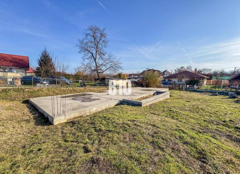 1786 m2 - základová doska - stavebné povolenie + projekt - Mojmírovce - Stavebný pozemok s betónovými základmi a zeleňou, ideálny pre bývanie.