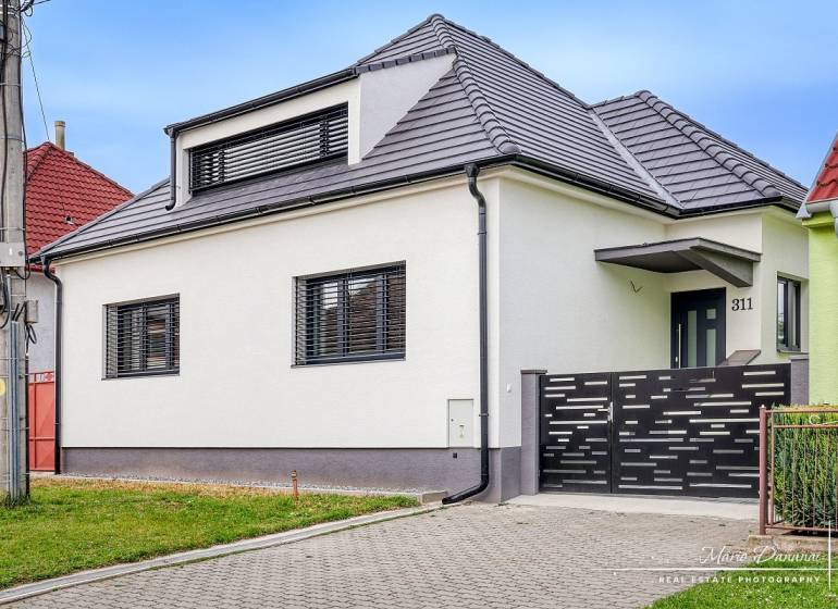 3-izbový moderne zrekonštruovaný rodinný dom v obci Jaslovské Bohunice - Rodinný dom na Orechovej ulici v Jaslovských Bohuniciach s modernou strechou a plotom.