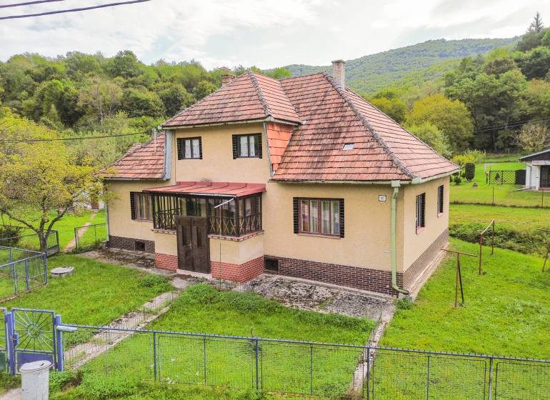 5i RD s garážou, Čierna Lehota, okr. Bánovce n./B. - Rodinný dom v Čiernej Lehote obklopený zeleňou, so šikmou strechou a záhradou.