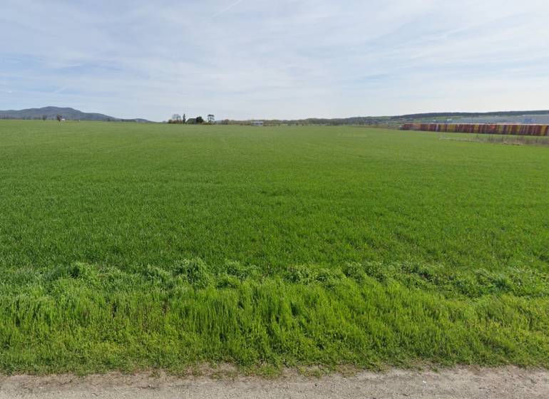 PREDAJ- Priemyselný pozemok 133.667 m2- 7 km od Jaguar-Landrover - Zelená lúka v Nitre, vhodná pre Pozemky - komerčné, s lesom v pozadí.