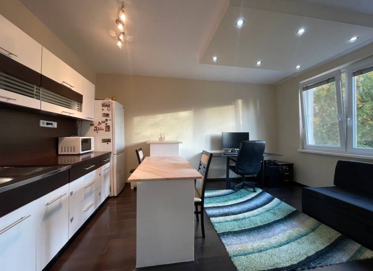 MH279-Na predaj 1 izbový byt v oblúbenej lokalite Komárna! - Kuchyňa v 1-izbovom byte s podlahou s dreveným dekorom a pracovným kútom.