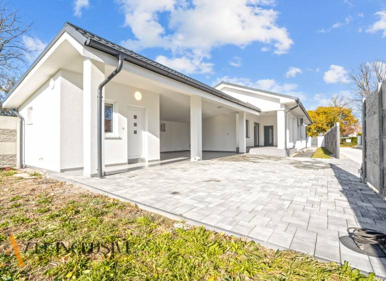 NA PREDAJ 4-IZB.BUNGALOV S DVOJGARÁŽOU,ORECHOVÁ POTôŇ - Rodinný dom v Orechovej Potôni s bielou fasádou a vydláždeným vstupom.