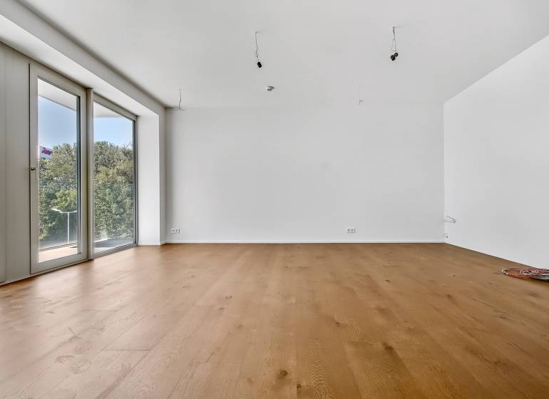 PREDAJ - LIGET Nový 2 izbový apartmán pri Sade Janka Kráľa, Petržalka - Priestranná izba so svetlým drevom a veľkými oknami v 2-izbovom byte.