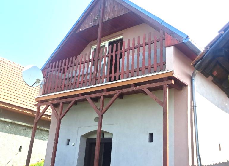 Predaj chaty a chalupy, Levice - Chata v Hontianskych Trsťanoch s dreveným balkónom a satelitnou anténou.