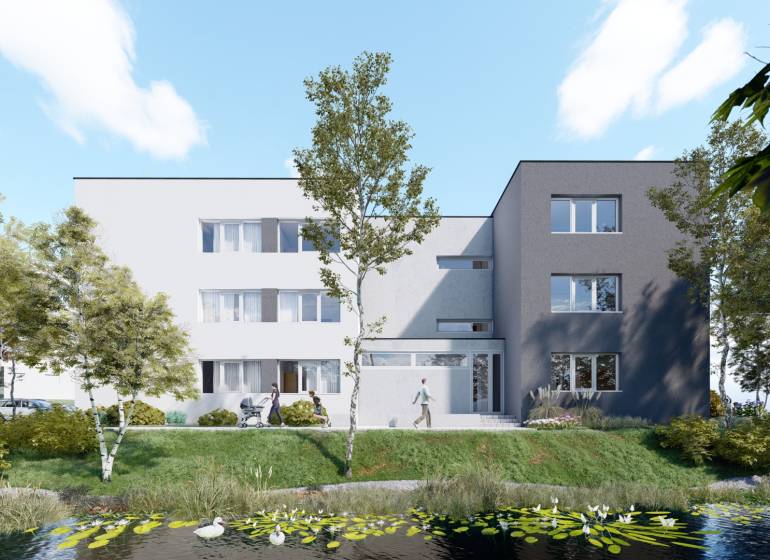 Pozemok s rozostavanou stavbou pre 12 bytov pri Senici - Na obrázku je bytový dom pri jazierku, zeleň a developerské pozemky.