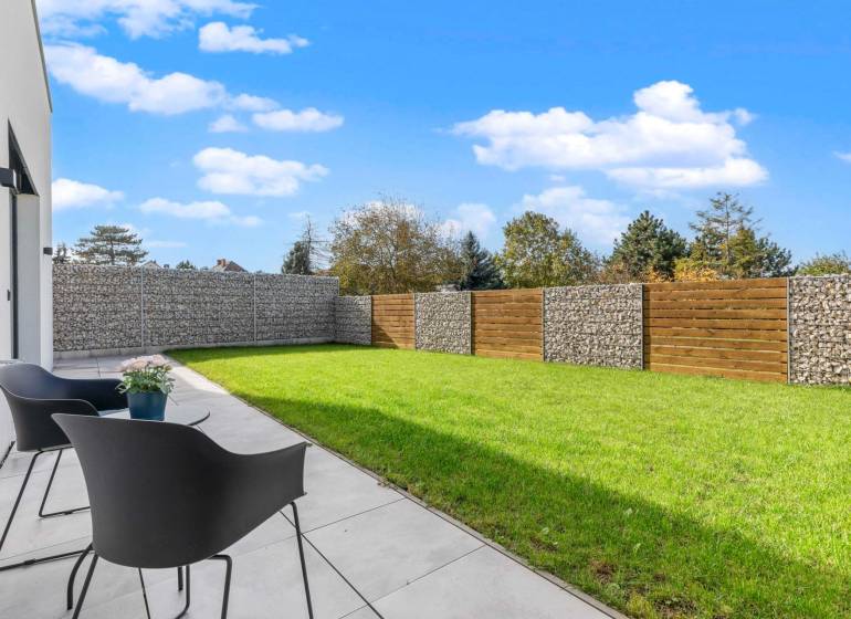 BÝVANIE VO VILA DOME - POSLEDNÝ VOĽNÝ 3-IZBOVÝ BYT SO ZÁHRADOU - Terasa s kreslami a trávnikom v 3-izbovom byte na ulici Lipnická, Dunajská Lužná.