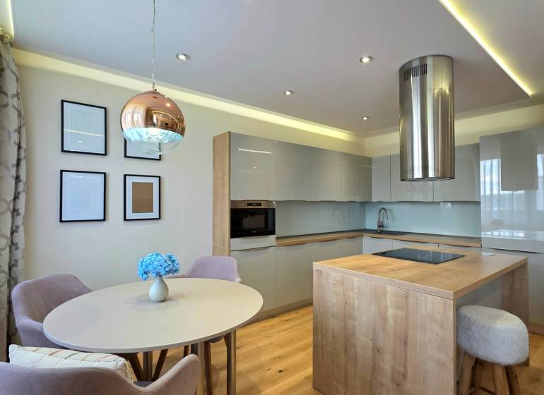 REZERVOVANÉ - 3i, OV, 71m2 + loggia, Lomonosovova, dizajnový, zariaden - Kuchyňa s jedálenským stolom a ostrovčekom, podlaha s dreveným dekorom, 3-izbový byt.