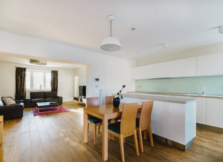 PREDAJ  kompletne prerobený 3 izbový rodinný dom, Nitra - centrum - Kuchyňa a obývačka v rodinnom dome s podlahou s dreveným dekorom a svetlým nábytkom.