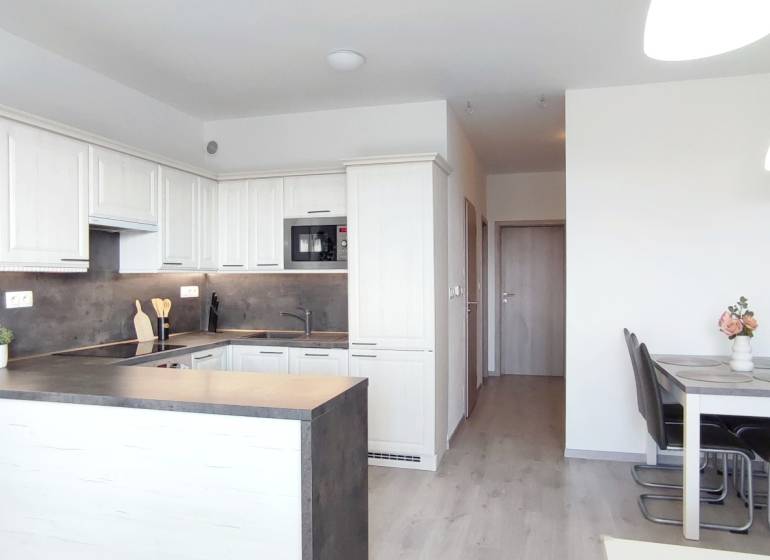 | 2-izbový byt, ul. Predmerského VINOHRADY | Trenčín  - Kuchyňa a jedálenský kút v 2-izbovom byte s podlahou s dreveným dekorom.