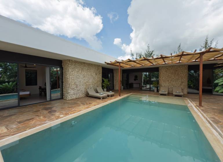 LUXURY 2-BEDROOM VILLA IN PAJE - Výstavba domov v Paje, Unguja South Region s bazénom a kamennými stenami na terase.