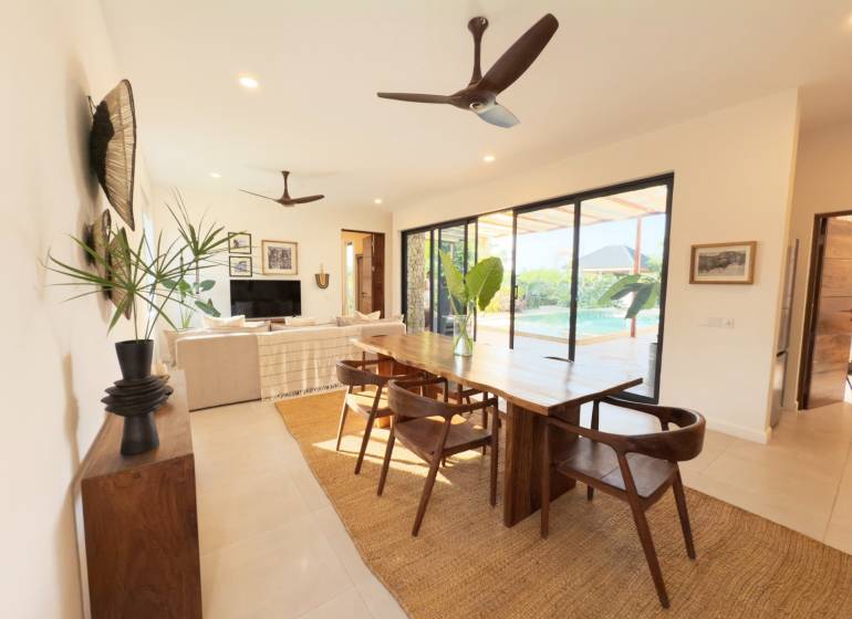 LUXURY 2-BEDROOM VILLA IN PAJE - Interiér s jedálenským stolom, podlahou s dreveným dekorom a veľkými sklenenými dverami, Výstavba domov.