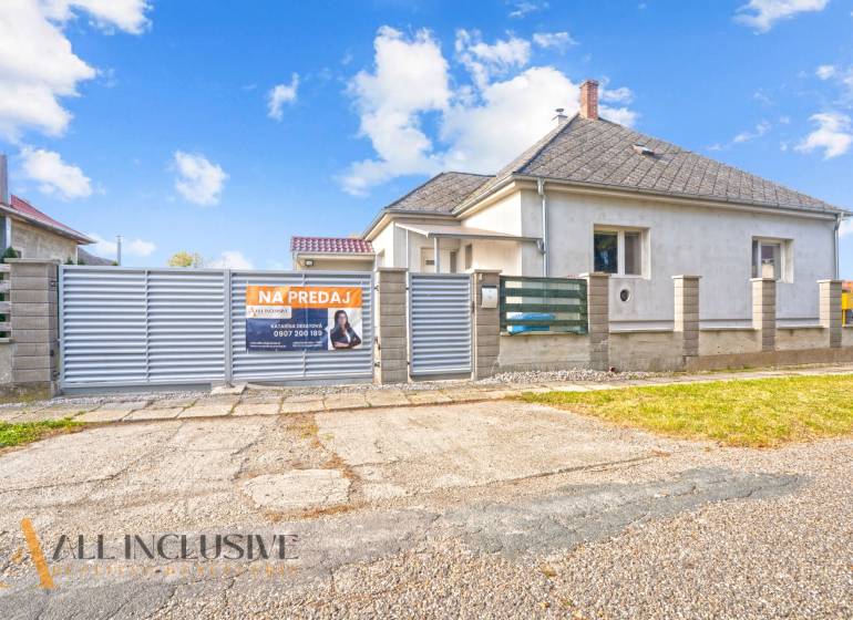 NA PREDAJ 4+1-IZBOVÝ ROD. DOM, VEĽKÉ KOSIHY - Rodinný dom v Veľkých Kosihách na predaj, biely fasádny obklad, široká brána.