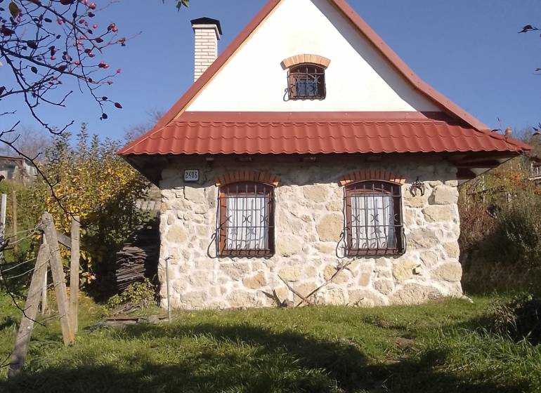 Štýlový rekreačný domček Levice - Klasická kamenná chata v Starých Leviciach, rekreačná lokalita, obklopená zeleňou a dreveným plotom.