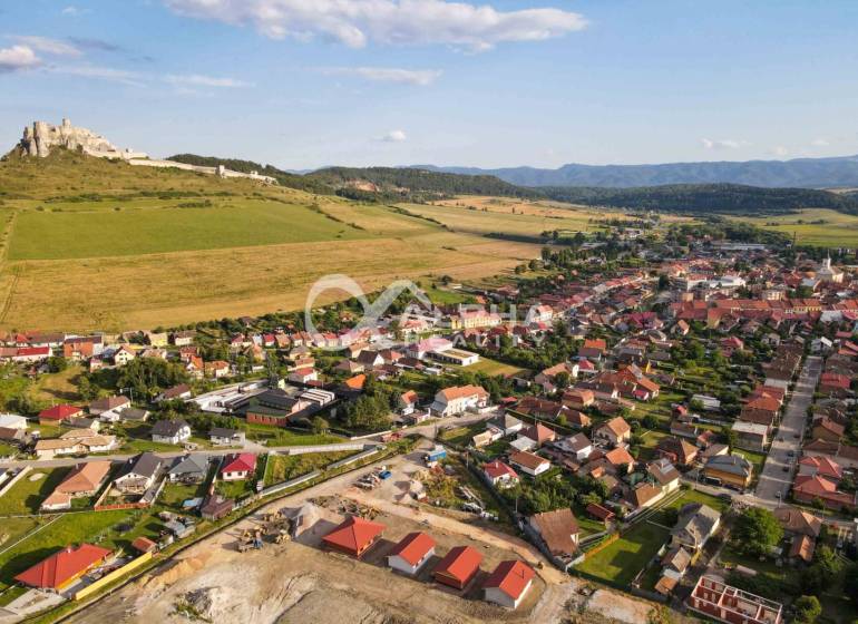 Exkluzívne novostavba rodinný dom - bungalov, Spišské Podhradie - Letecký pohľad na rodinné domy v Spišskom Podhradí s hradom a prírodou v pozadí.