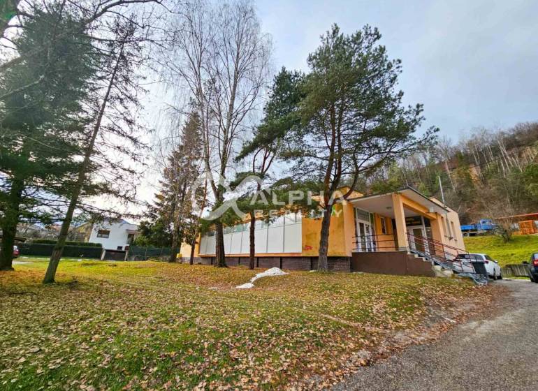 Budova s pozemkom, obec Helcmanovce, okres Gelnica - Budova v Helcmanovciach obklopená stromami, so schodiskom vedúcim k vchodu.