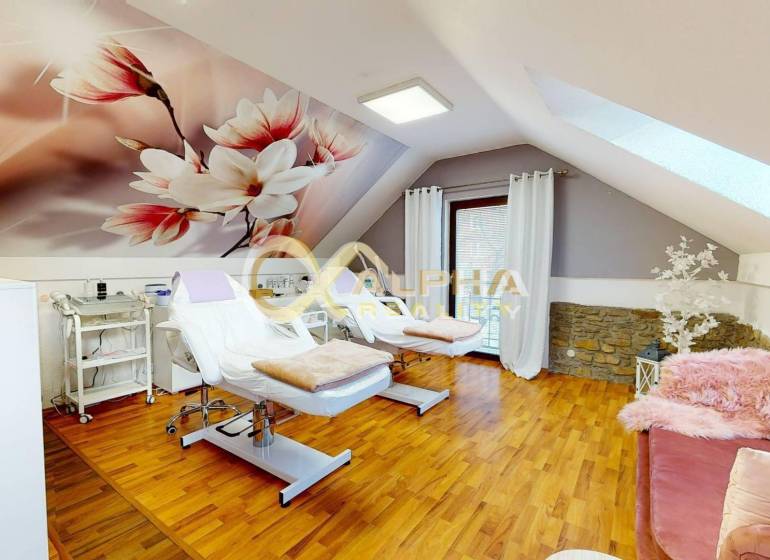 Prenájom priestorov, centrum, Spišská Nová Ves - Interiér kancelárie s kreslami a podlahou s dreveným dekorom, dekoratívna stena s kvetmi.