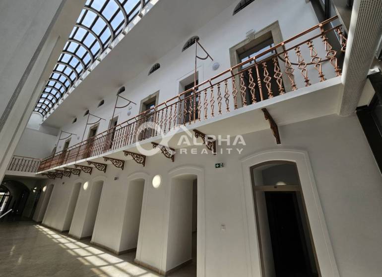 Prenájom obchodných priestorov, 268m2, Letná ulica, Spišská Nová Ves - Obchodné priestory s presklenou strechou a ozdobným zábradlím na poschodí.