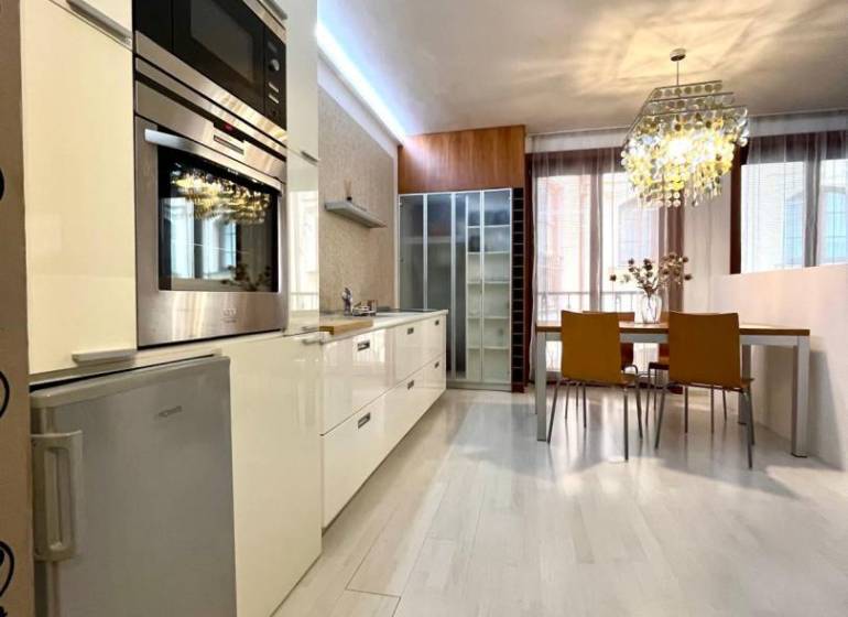 Vám EXKLUZÍVNE ponúka NA PRENÁJOM moderný 2 iz - Kuchyňa s jedálenským kútom v 2-izbovom byte, podlaha s dreveným dekorom, štýlový luster.