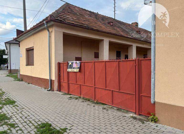Reality KOMPLEX Vám ponúka EXKLUZÍVNE na predaj rodinný dom, ktorý sa  - Rodinný dom vo Veľkom Mederi s červenou bránou a tehlovým základom.