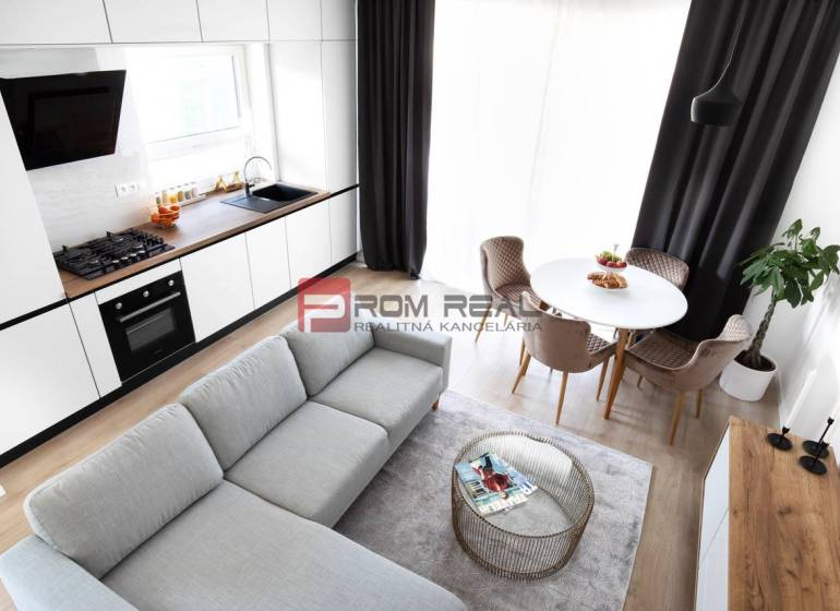Na predaj 3 izbový dvojpodlažný byt Ivanka pri Dunaji - Kuchyňa s obývačkou v 3-izbovom byte, biely nábytok, podlaha s dreveným dekorom.