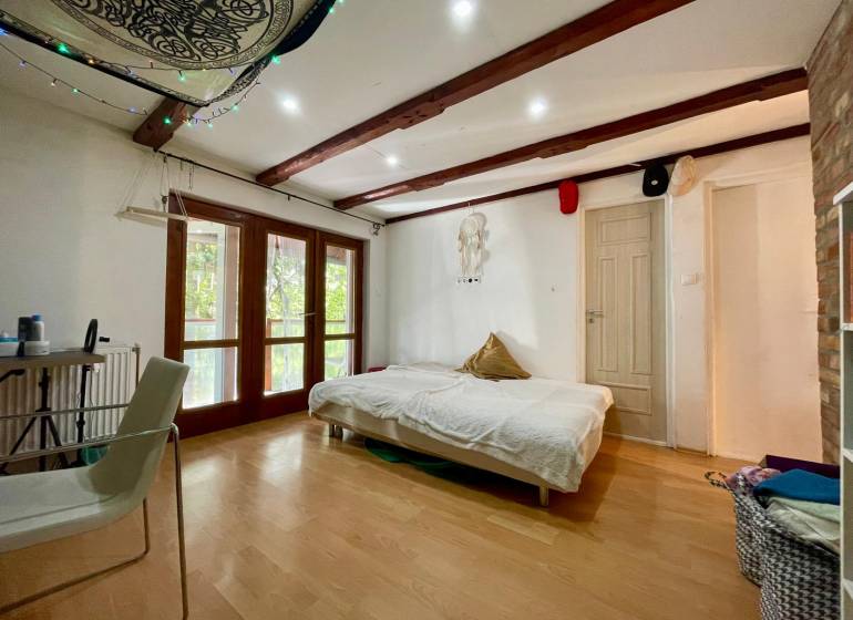 4 izbová celoročná chata v Kučišdorfskej doline na predaj - Interiér chaty s posteľou, stoličkou a podlahou s dreveným dekorom.