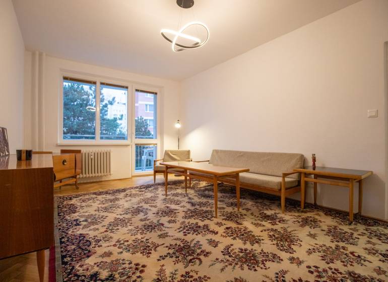 Slnečný 3-izbový byt, Kramáre - Obývačka v 3-izbovom byte so starožitným kobercom a dreveným nábytkom.