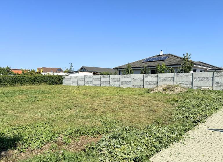 Na predaj stavebný pozemok s IS, Kvetoslavov 643 m² - Pozemok na Bazovej ulici v Kvetoslavove, vhodný na bývanie, s oplotením a trávnatou plochou.