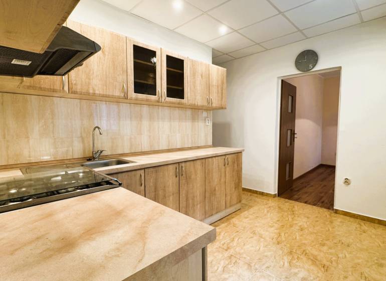 Výborná poloha, skvelá dispozícia – 3-izbový byt v Trebišove - Kuchyňa v 3-izbovom byte s kuchynskou linkou a podlahou s dreveným dekorom.