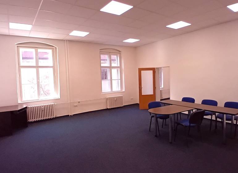 Na prenájom priestor- kancelária 60 m2 Trnava - Františkánska - Veľká kancelária s kobercovou podlahou, stolom a stoličkami.