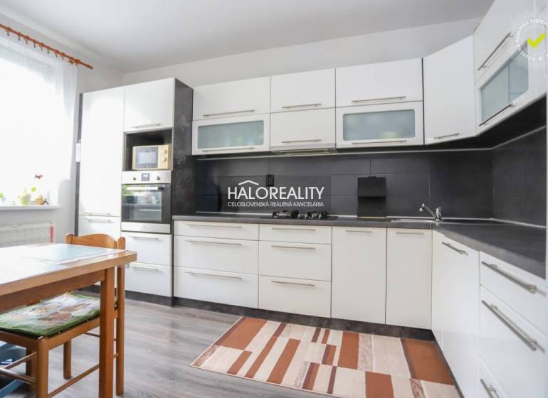 REZERVOVANÉ - Predaj, trojizbový byt Považská Bystri... - Kuchyňa v 3-izbovom byte s bielymi skrinkami a podlahou s dreveným dekorom.
