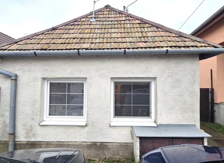 Na predaj 2 izbový rodinný dom, Dolné Orešany! - Rodinný dom v Dolných Orešanoch s klasickou strechou a dvomi oknami v popredí.