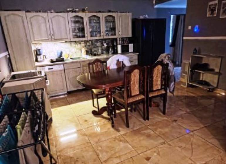 Rodinný dom na veľkorysom pozemku v Drahňove. - Kuchyňa v rodinnom dome s keramickou dlažbou, drevené skrinky a jedálenský stôl.