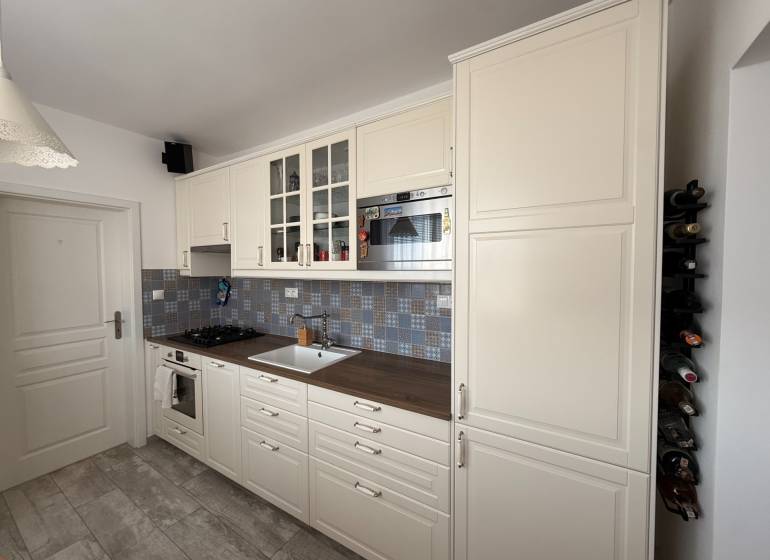 KRÁSNY, ÚTULNÝ A ŠTÝLOVÝ 3 IZBOVÝ BYT | DUBRAVKA - Kuchyňa v 3-izbovom byte s bielymi skrinkami a podlahou s dreveným dekorom.