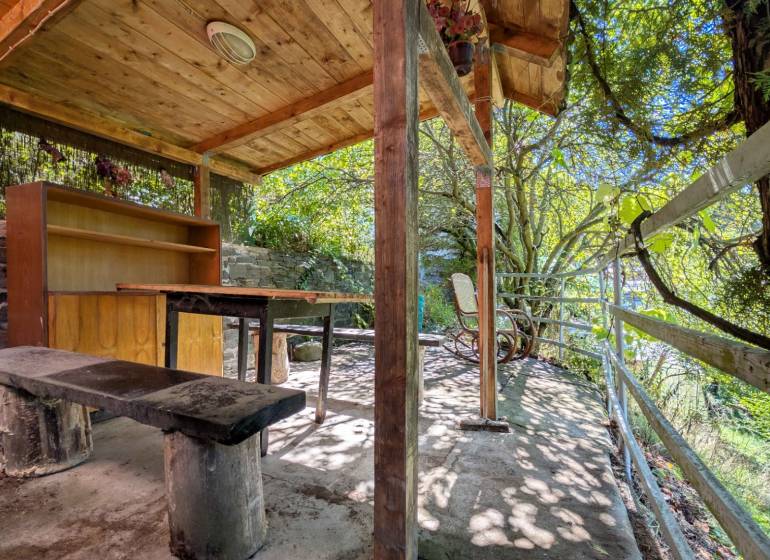 ZÁHRADA S UNIMOBUNKOU A VÝHĽADOM NA ZVOLEN , 465M2, ZVOLEN – HÁJIK - Prístrešok so stolom a lavičkou pod drevenou strechou v Záhradách na Hájiku vo Zvolene.