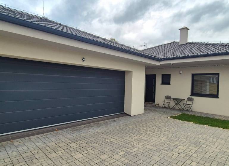 Na predaj 4 izbový RD v obci  Studienka, garáž, sauna, pozemok 719 m2 - Rodinný dom v Studienke s dvoma stoličkami a stolíkom na dláždenom dvore.