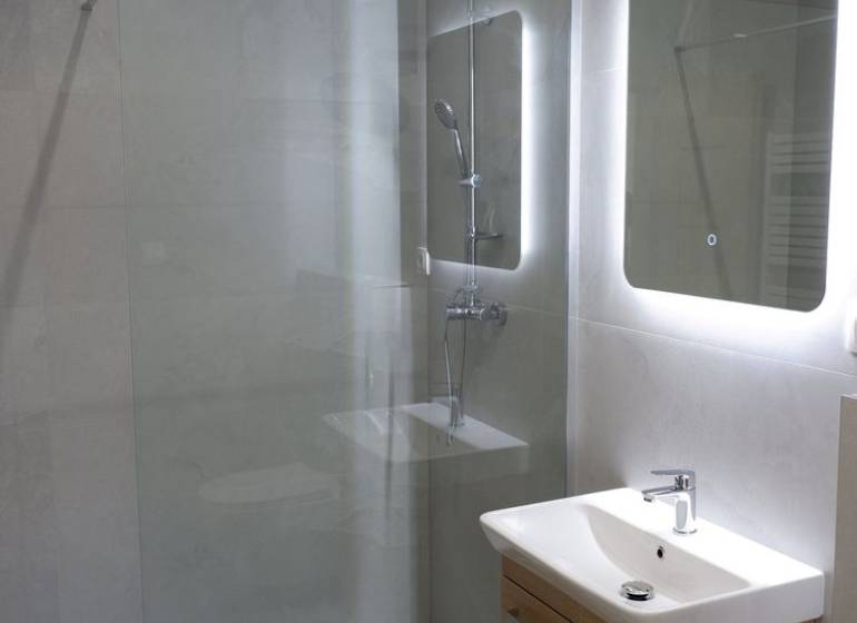 Ponúkame na predaj 4izb rodinný dom v štandarde v obci Radava - Kúpeľňa s umývadlom, sprchovým kútom a veľkým zrkadlom v rodinnom dome.