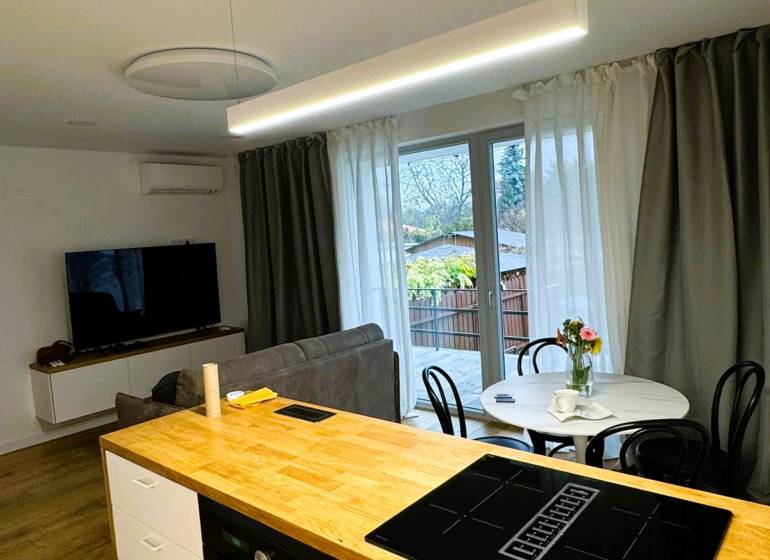 5 - izbový rodinný dom - 168 m², na pozemku 223 m², Ivanka pri Dunaji - Kuchynský ostrovček s varnou doskou, jedálenský stôl a pohovka v rodinnom dome.