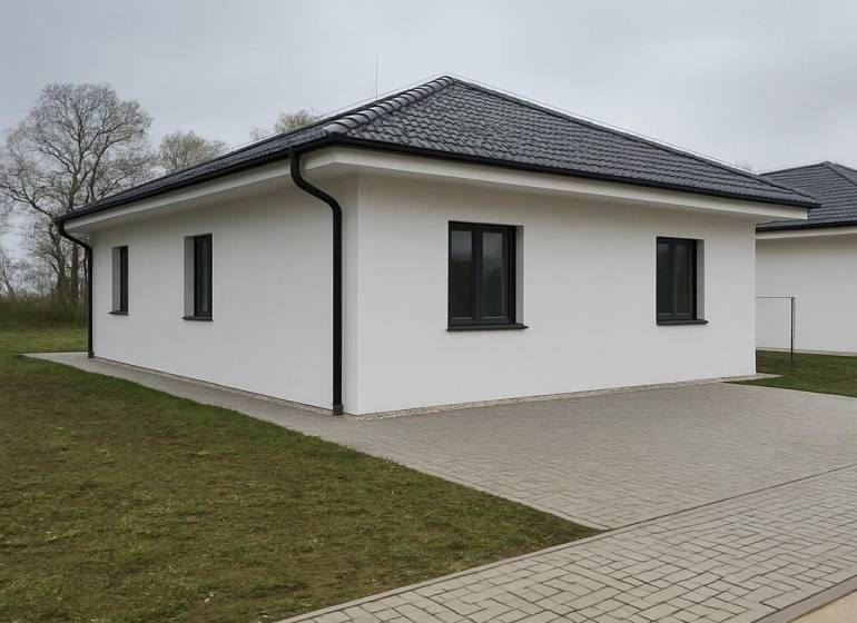 Moderný nízkoenergetický 4-izbový rodinný dom, Cífer – Karlov Dvor - Rodinný dom v Cíferi so šikmou strechou a dláždeným chodníkom.