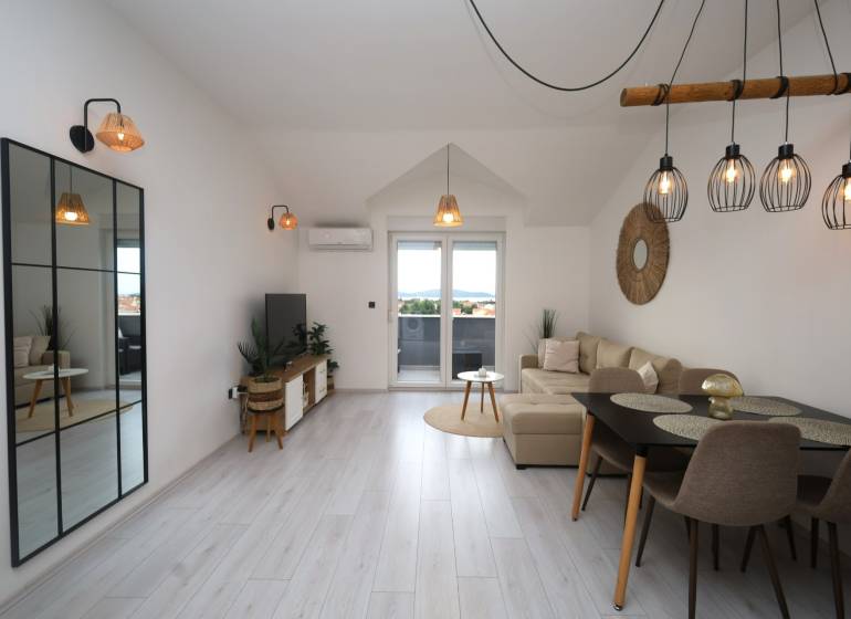 Vodice – novo zrekonštruovaný dvojspálňový apartmán s výhľadom na more - Obývacia izba v Rekreačnom apartmáne s podlahou s dreveným dekorom a veľkým zrkadlom.