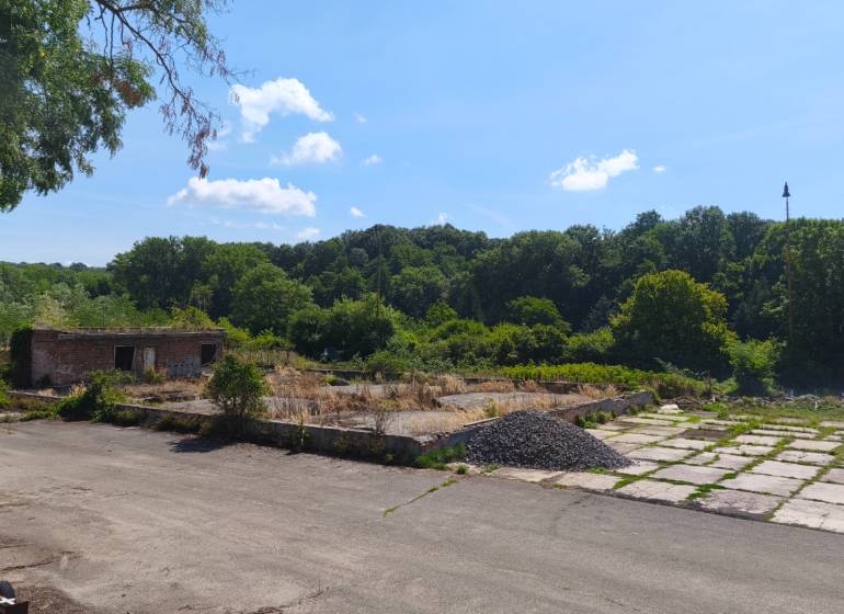 Pozemok o rozlohe 1880 m2  vo Veľkom Krtíši. - Pozemky - komerčné na Lučeneckej ceste vo Veľkom Krtíši s opustenou stavbou, obklopené stromami.