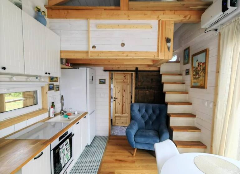 Tiny house - malý domček - Štýlová kuchyňa so sedacím kútom v rodinnom dome s podlahou s dreveným dekorom.