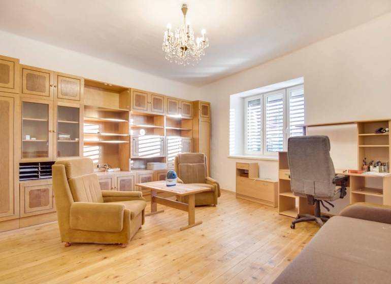 Rodinný dom s garážou na ul. Pod kopcom, Nové Zámky, 649m2 - Interiér rodinného domu s nábytkom, podlahou s dreveným dekorom a lustrom.